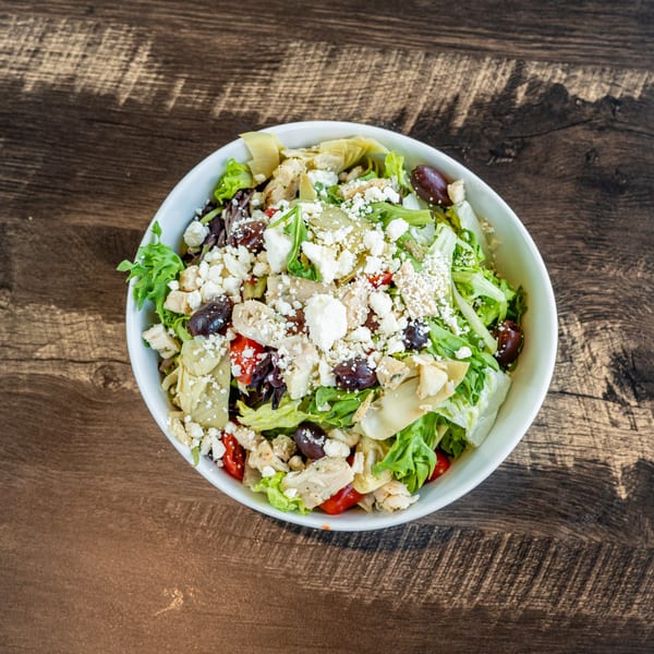 Invictus Pizza Kitchen's fresh salad with feta, olives, artichoke hearts, and cherry tomatoes.